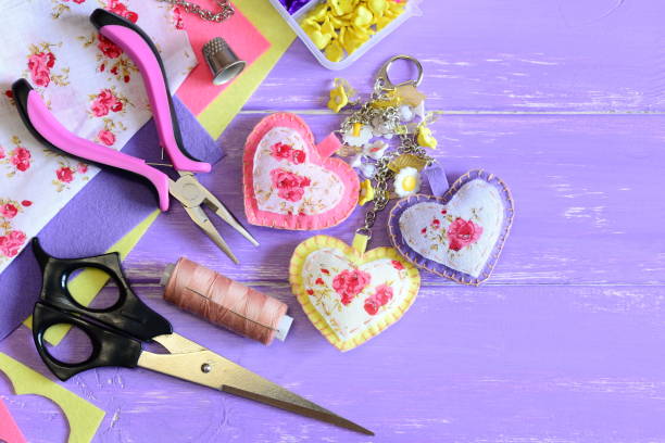 Decorative hearts keychain. Handmade felt and fabric keychain on bag or backpack. Summer accessory for women or girls. Crafts and craft supplies background stock photo