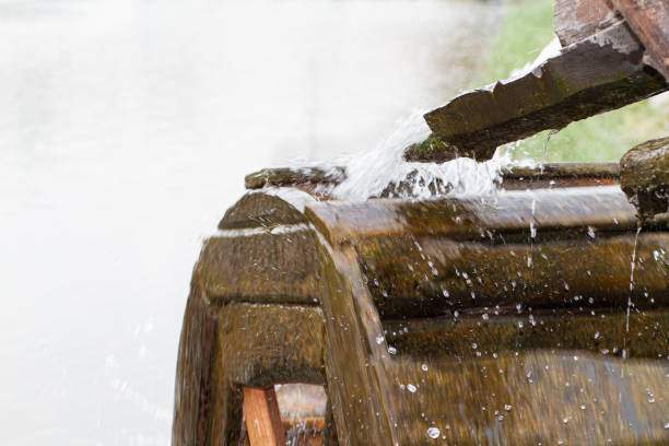 Decorative water mill wheel and splashes of water. Wooden watermill. Wooden water mill water wheel stock pictures, royalty-free photos & images