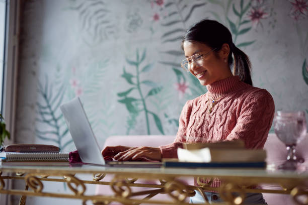 A dedicated student on student exchange is sitting in a coffee shop and typing on her laptop. Student exchange. A dedicated student on student exchange is sitting in a coffee shop and typing on her laptop. Student exchange. free degree stock pictures, royalty-free photos & images