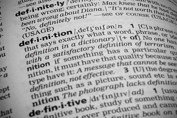 Definition in Dictionary Closeup shot of the word definition in a dictionary. Page curves and has a vignetting or edge burn effect where the corners are darker. Focus is on the word definition. dictionary stock pictures, royalty-free photos & images