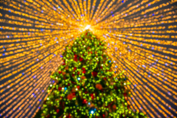 Defocused christmas tree silhouette with blurred lights stock photo