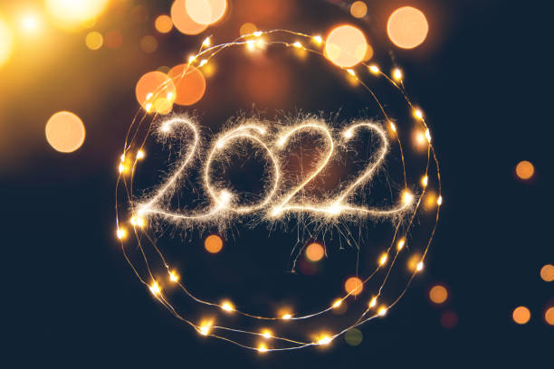 Defocused light background with circular light garland and New year 2022 stock photo