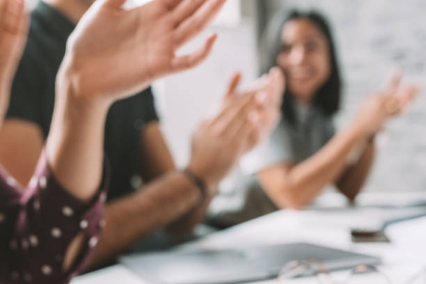 defocused photo of partners clapping hands after business seminar stock photo