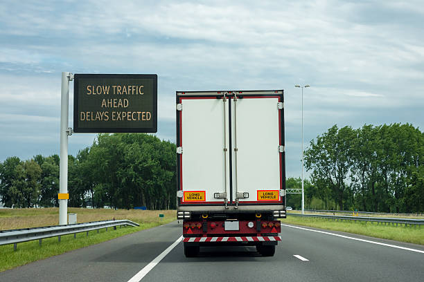 Delay Expected left drive Rear view  of Truck on highway with  matrix display  Delay Expected Message. The no delays version or lefthand  drive are also available, even a social media in the car warning semi truck back stock pictures, royalty-free photos & images