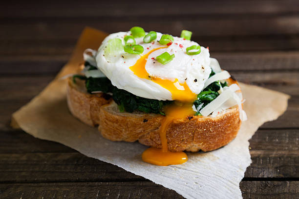 Delicious benedict eggs Delicious benedict eggs prepared on a wood table in kitchen poached food photos stock pictures, royalty-free photos & images