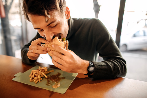 Young man eating burger