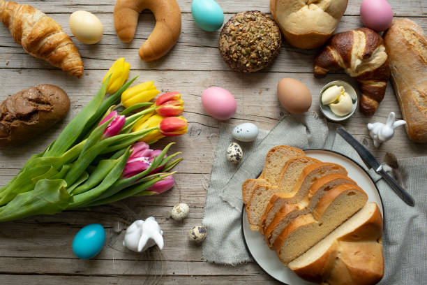 delicious fresh easter breakfast with easter pastry and easter bread and beautiful colorful flowers tulips with decoration bunny and eggs on wooden background stock photo
