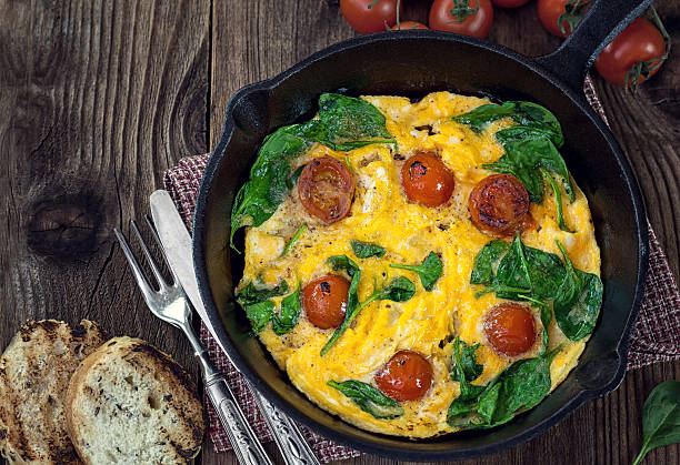 Delicious frittata with spinach and tomatoes stock photo