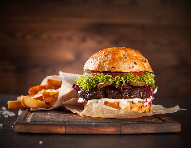 Delicious hamburger on wood Delicious hamburger served on wooden planks burger stock pictures, royalty-free photos & images