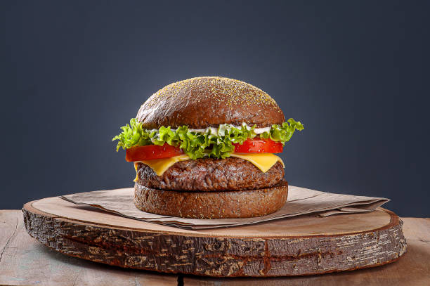 Delicious hamburger served on Australian bread. Wooden table and gray background. Copy space Delicious hamburger served on Australian bread. Wooden table and gray background. Copy space artisanal food and drink photos stock pictures, royalty-free photos & images