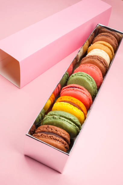 delicious macaroons on pastel color background stock photo