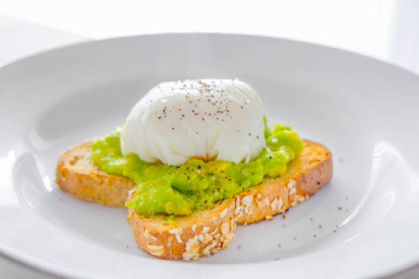 Delicious poached egg and avocado toast Delicious poached egg and avocado toast poached food photos stock pictures, royalty-free photos & images