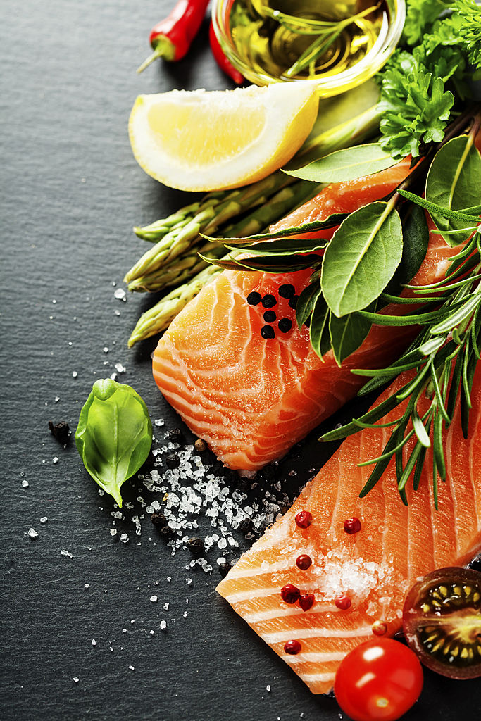 Porsi lezat fillet salmon segar dengan bumbu aromatik, rempah-rempah dan sayuran - makanan sehat, diet atau konsep memasak