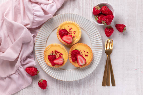 Delicious small tartlet pastries topped with strawberry fruits stock photo
