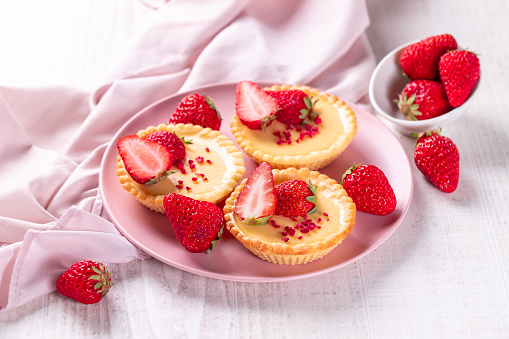 Delicious small tartlet pastries topped with strawberry fruits