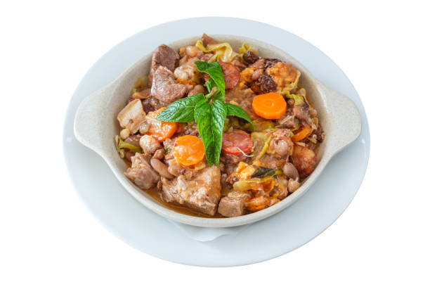 Delicious traditional Portuguese dish feijoada and sewn with smoked sausage with carrots with cabbage and mint leaves. On isolated white background. stock photo