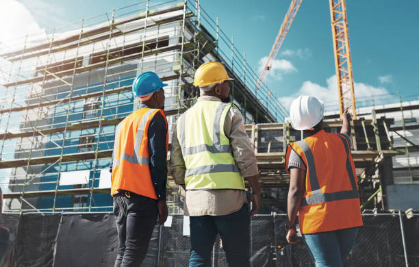 Delivering quality construction for a quality lifestyle Shot of a group of builders assessing progress at a construction site construction site stock pictures, royalty-free photos & images