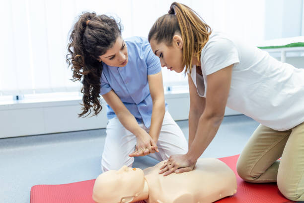 Demonstrating CPR (Cardiopulmonary resuscitation) training medical procedure on CPR doll in the class.Doctor and nurse students are learning how to rescue the patient.First aid for safe life concept. stock photo