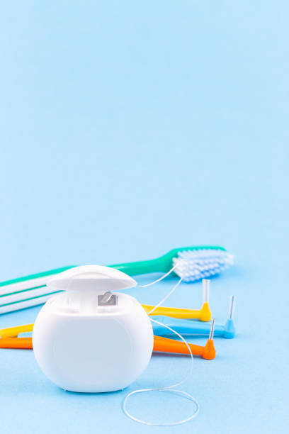 Dental floss, toothbrush and interdental brush angles on blue background, vertical, copy space stock photo