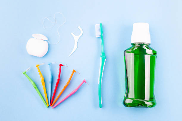 Dental floss, toothbrush, interdental brush angles and mouthwash on blue stock photo