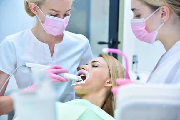 Dentist and assistant scaning patient's teeth with   intraoral 3d scanner. stock photo