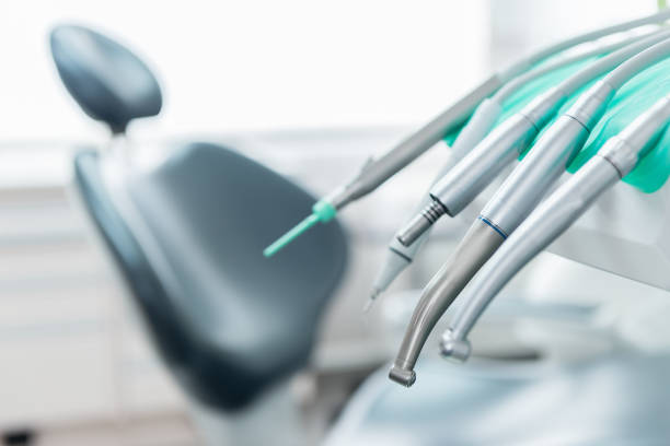 Dentist tools & equipment Horizontal color close-up image of dentist tools and dentist's chair in the background. dentist stock pictures, royalty-free photos & images