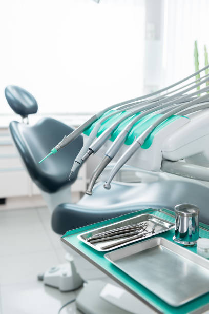 Dentist tools Vertical color close-up image of dentist tools and dentist's chair in the background. silver teeth stock pictures, royalty-free photos & images