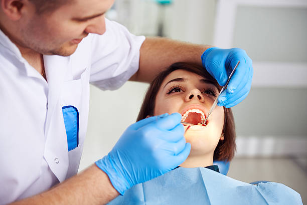Dentist with patient Male doctor in uniform checking up female patient's teeth in dental clinic. Concept of oral examination, toothache and decay treatment. dental cavity stock pictures, royalty-free photos & images