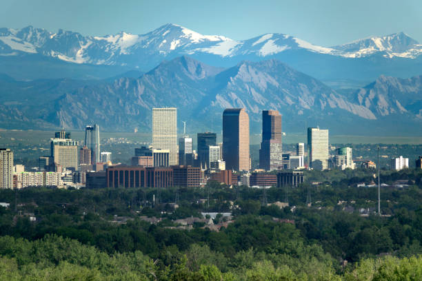 Denver Colorado downtown skyscrapers Boulder Flatirons red rocks Indian Peaks Rocky Mountains The snow covered Rocky Mountains and Indian Peaks rise over wind turbines, Boulder Flatirons and Downtown Denver skyscrapers, hotels, office and apartment buildings. boulder colorado stock pictures, royalty-free photos & images