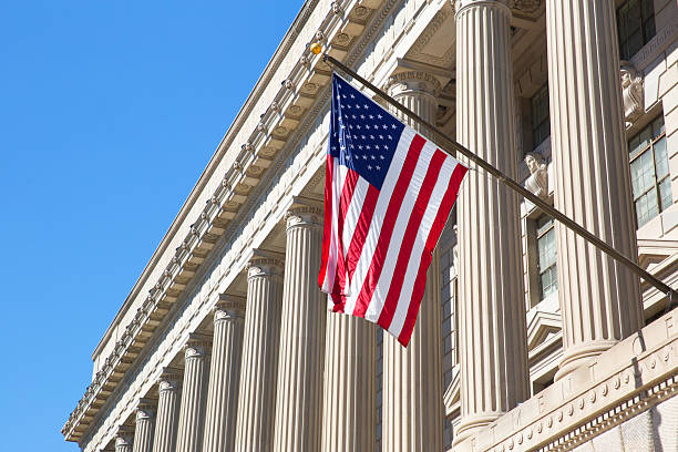 Department of Commerce in Washington Department of Commerce in Washington DC, America. American flag flying.  federal building stock pictures, royalty-free photos & images