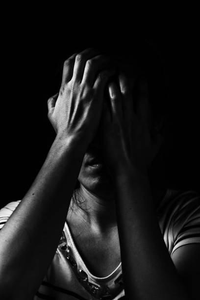 depress woman standing in the dark in white tone stock photo