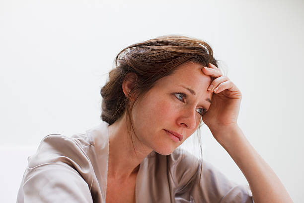 Depressed woman with head in hands  mid adult women stock pictures, royalty-free photos & images
