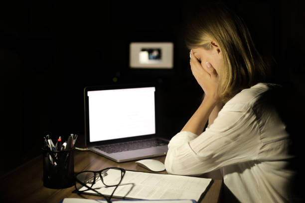 deprimerad kvinna som arbetar med datorn på natten - trakasserier bildbanksfoton och bilder