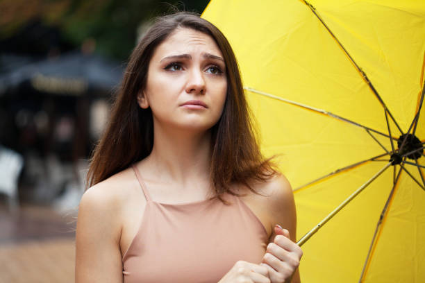 Depressed young woman holding an umbrella stock photo