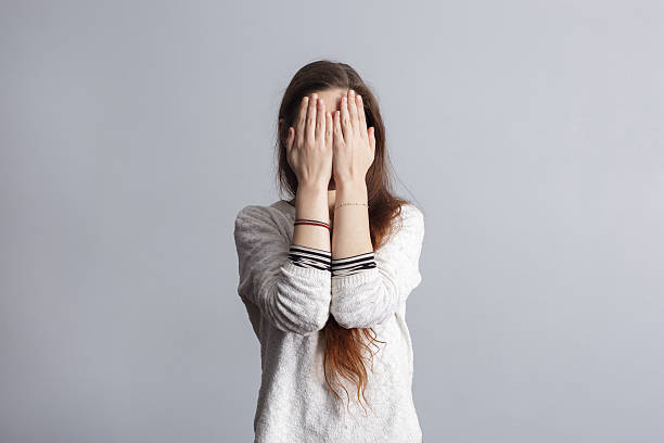 Depression and loneliness in youth. Girl with long hair covers his face with his hands. depression land feature stock pictures, royalty-free photos & images