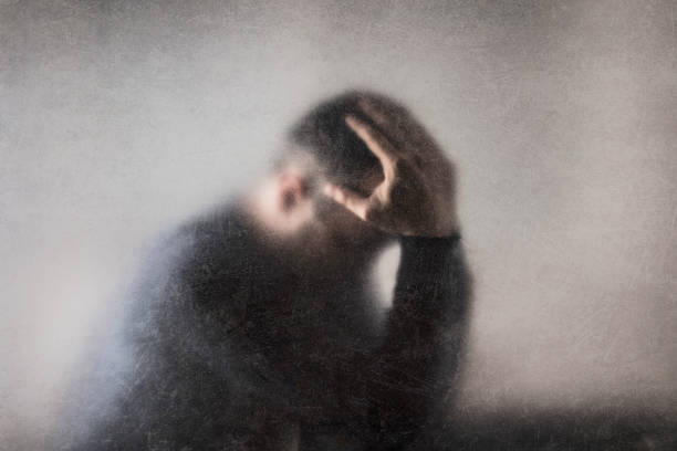 Depression. Broken man behind a dusty scratched glass. stock photo