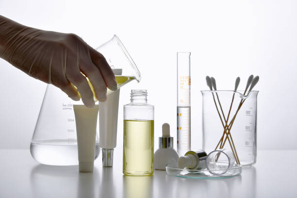 Dermatologist formulating and mixing pharmaceutical skincare, Cosmetic bottle containers and scientific glassware, Research and develop beauty product concept. stock photo