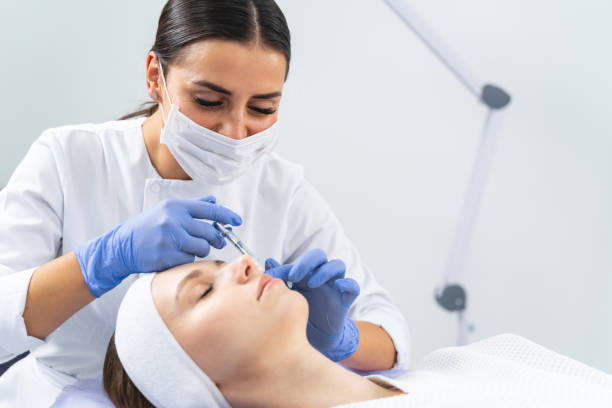 Dermatologist injecting a cheek filler to a woman Young patient lying with her eyes closed during the anti-wrinkle injection in a beauty salon beauty treatment stock pictures, royalty-free photos & images