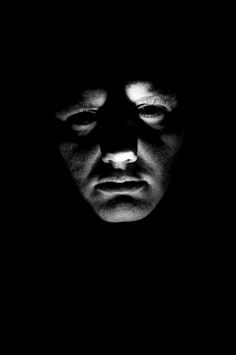 desaturated-mans-face-illuminated-from-below-with-flashlight-picture-id544344514