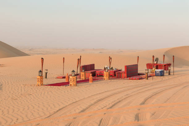 Desert dinner set up for sunset romantic meal at sand dunes with carpets and cushions stock photo