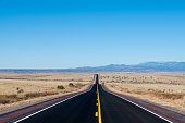 istock Desert highway in a vast barren landscape with distant mountains 1197944021
