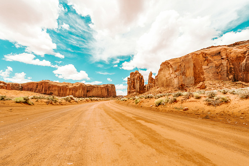 A red-sand desert road at Monument Valley on the Arizona-Utah border known for the towering sandstone buttes.