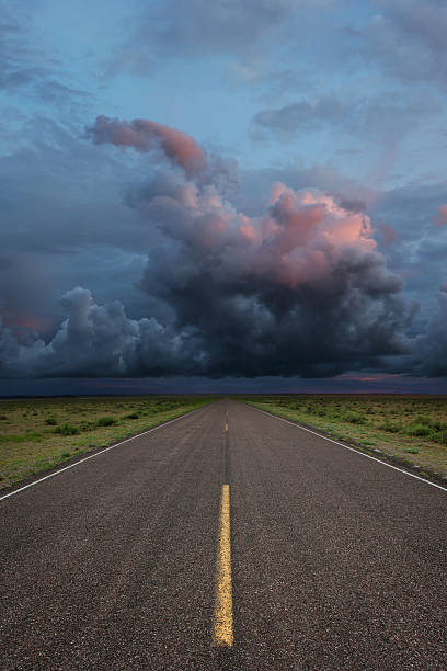XXL desert road thunderstorm desert road with dramatic storm clouds, vertical frame (XXL) storm on the horizon stock pictures, royalty-free photos & images