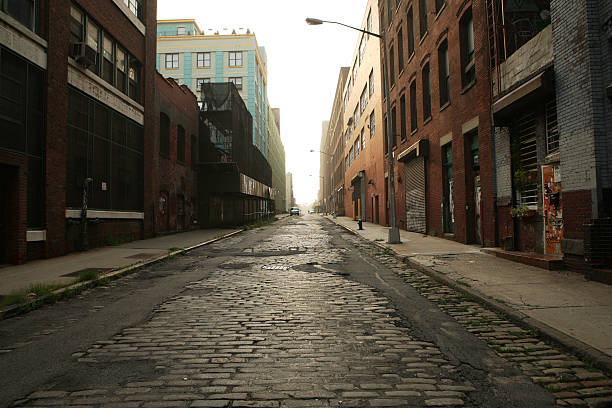 Deserted Brooklyn DUMBO Cobblestone Backstreet Morning Looking into the rising sun up a deserted Brooklyn, DUMBO, backstreet at dawn. cobblestone stock pictures, royalty-free photos & images