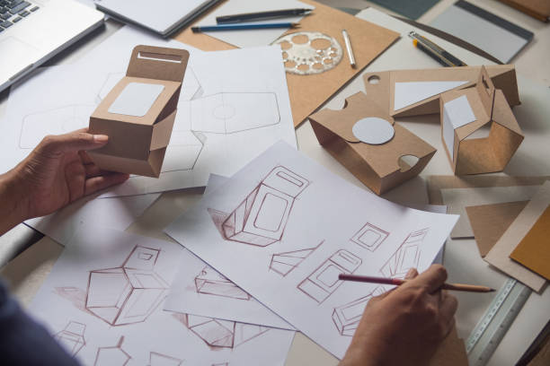 Designer sketching drawing design Brown craft cardboard paper product eco packaging mockup box development template package branding Label . designer studio concept . stock photo