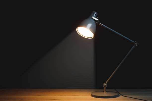 desk lamp with spotlight, black background with copy-space stock photo