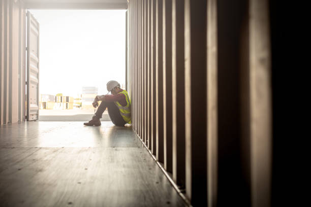 wanhoop personeel in logistieke bedrijf sittng in container - bouwvakker stockfoto's en -beelden