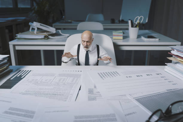 Desperate businessman checking financial reports stock photo