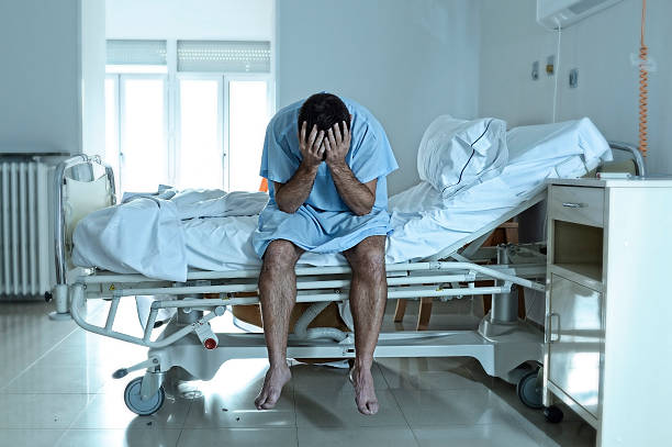 desperate sick man at hospital bed alone sad and depressed stock photo