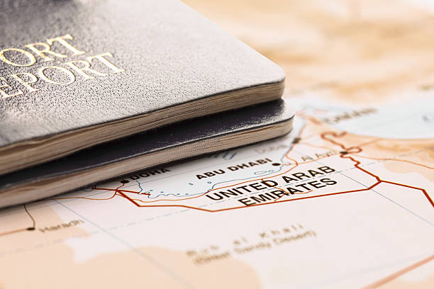 Two passports on the map of United Arab Emirates, are ready for travel. The map is toned in pastel colors. Concept: Planning travel destinations or journey planning. Close-up view. Studio shot. Landscape orientation.